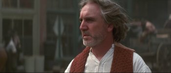 Movie still from “Ride with the Devil” (1999), directed by Ang Lee – A man with long gray hair wearing a red scarf; Close Up shot, Over the shoulder angle