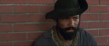 Movie still from “Ride with the Devil” (1999), directed by Ang Lee – A man with a beard wearing a black hat; Close Up shot, Low angle
