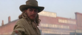 Movie still from “Ride with the Devil” (1999), directed by Ang Lee – A man with long hair wearing a cowboy hat; Close Up shot, Over the shoulder angle