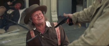 Movie still from “Ride with the Devil” (1999), directed by Ang Lee – An older man in a cowboy hat is holding a gun; Medium shot, Over the shoulder angle