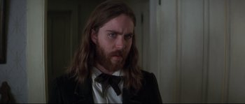 Movie still from “Ride with the Devil” (1999), directed by Ang Lee – A man with long hair wearing a suit and tie; Close Up shot, Over the shoulder angle