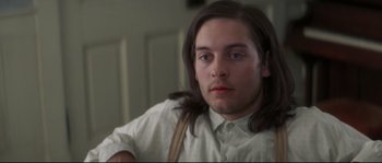 Movie still from “Ride with the Devil” (1999), directed by Ang Lee – A man with long brown hair sitting in front of a guitar; Close Up shot, Low angle