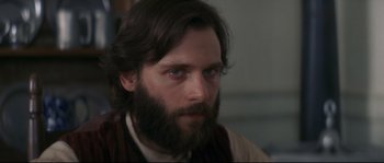 Movie still from “Ride with the Devil” (1999), directed by Ang Lee – A man with long hair and a goatee stares into the camera; Close Up shot, Over the shoulder angle