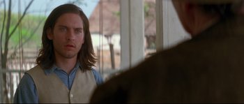 Movie still from “Ride with the Devil” (1999), directed by Ang Lee – A man with long brown hair standing in front of a window; Close Up shot, Over the shoulder angle