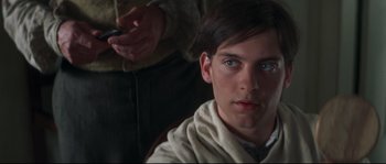 Movie still from “Ride with the Devil” (1999), directed by Ang Lee – A young man is looking into the camera while holding a cell phone; Close Up shot, Over the shoulder angle