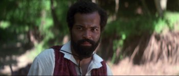 Movie still from “Ride with the Devil” (1999), directed by Ang Lee – A man with a black beard and a red vest; Close Up shot, Low angle