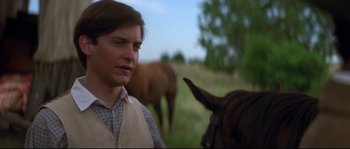 Movie still from “Ride with the Devil” (1999), directed by Ang Lee – A man standing next to a horse in a field; Close Up shot, Over the shoulder angle