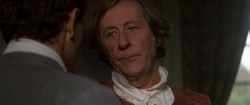 Movie still from “Ridicule” (1996), directed by Patrice Leconte – A person wearing a neck scarf; Close Up shot, Over the shoulder angle