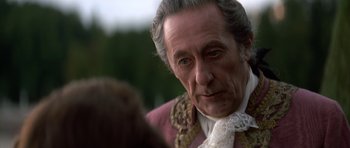 Movie still from “Ridicule” (1996), directed by Patrice Leconte – An older man wearing a pink jacket and a white shirt; Close Up shot, Over the shoulder angle