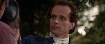 Movie still from “Ridicule” (1996), directed by Patrice Leconte – A person wearing a suit and tie; Close Up shot, Low angle