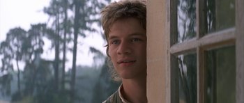 Movie still from “Ridicule” (1996), directed by Patrice Leconte – A young man is looking out of a window; Close Up shot, Low angle