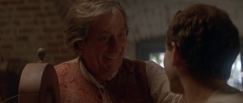 Movie still from “Ridicule” (1996), directed by Patrice Leconte – An older man smiling at a younger man; Close Up shot, Over the shoulder angle