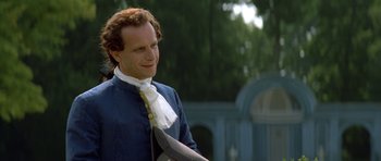 Movie still from “Ridicule” (1996), directed by Patrice Leconte – A man in a blue shirt and a white neck tie; Medium shot, Over the shoulder angle