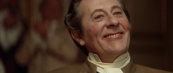 Movie still from “Ridicule” (1996), directed by Patrice Leconte – An older man wearing a white shirt and a white tie; Close Up shot, Low angle