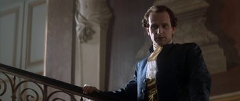 Movie still from “Ridicule” (1996), directed by Patrice Leconte – A man standing on top of a wooden railing; Medium shot, Low angle