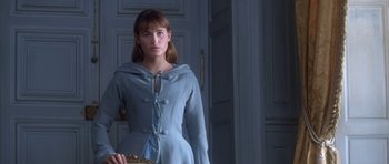 Movie still from “Ridicule” (1996), directed by Patrice Leconte – A woman in a blue dress standing in front of a door; Medium shot, Over the shoulder angle