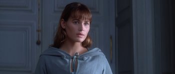 Movie still from “Ridicule” (1996), directed by Patrice Leconte – A young woman wearing a hooded sweatshirt looks to her left; Close Up shot, Over the shoulder angle