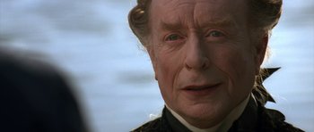 Movie still from “Ridicule” (1996), directed by Patrice Leconte – An old man with a long white hair and blue eyes; Close Up shot, Over the shoulder angle