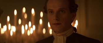 Movie still from “Ridicule” (1996), directed by Patrice Leconte – A person wearing a suit and tie; Close Up shot, Over the shoulder angle