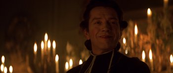 Movie still from “Ridicule” (1996), directed by Patrice Leconte – A person wearing a priest's outfit; Close Up shot, Over the shoulder angle