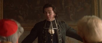 Movie still from “Ridicule” (1996), directed by Patrice Leconte – A man in a green jacket and a black and white neck tie; Close Up shot, Low angle