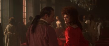 Movie still from “Ridicule” (1996), directed by Patrice Leconte – A man and a woman standing next to each other in a room; Medium shot, Over the shoulder angle