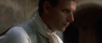 Movie still from “Ridicule” (1996), directed by Patrice Leconte – A person wearing a neck scarf; Close Up shot, Over the shoulder angle