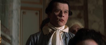 Movie still from “Ridicule” (1996), directed by Patrice Leconte – A person wearing a neck tie; Close Up shot, Over the shoulder angle