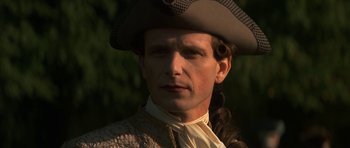 Movie still from “Ridicule” (1996), directed by Patrice Leconte – A person wearing a hat; Close Up shot, Over the shoulder angle