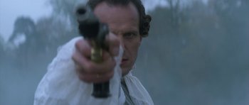 Movie still from “Ridicule” (1996), directed by Patrice Leconte – A man holding a gun in his hand; Close Up shot, Over the shoulder angle