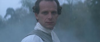 Movie still from “Ridicule” (1996), directed by Patrice Leconte – A person wearing a white shirt; Close Up shot, Over the shoulder angle