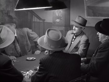 Movie still from “Rififi” (1955), directed by Jules Dassin – A group of men sitting at a table playing cards; Medium shot, High angle