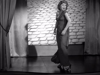 Movie still from “Rififi” (1955), directed by Jules Dassin – A black and white photo of a woman in a long dress; Wide shot, Low angle