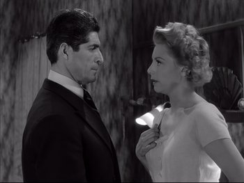 Movie still from “Rififi” (1955), directed by Jules Dassin – A man and a woman standing next to each other; Medium shot, Low angle