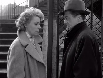 Movie still from “Rififi” (1955), directed by Jules Dassin – An older man and a younger woman standing next to each other; Medium shot, High angle