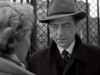Movie still from “Rififi” (1955), directed by Jules Dassin – An older man wearing a hat and a coat; Close Up shot, Over the shoulder angle