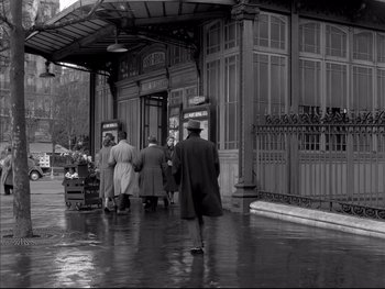 Movie still from “Rififi” (1955), directed by Jules Dassin – A black and white photo of a group of people walking down the street; Wide shot, High angle