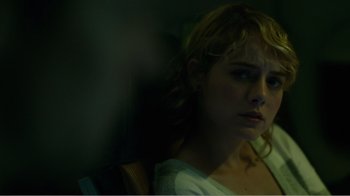 Movie still from “Rings” (2017), directed by F. Javier Gutiérrez – A young woman with blonde curly hair looking at the camera; Close Up shot, Over the shoulder angle