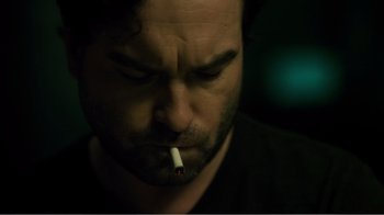 Movie still from “Rings” (2017), directed by F. Javier Gutiérrez – A person with a cigarette in his mouth; Close Up shot, Over the shoulder angle