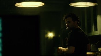 Movie still from “Rings” (2017), directed by F. Javier Gutiérrez – A man standing in the dark with a cigarette in his mouth; Medium shot, Low angle