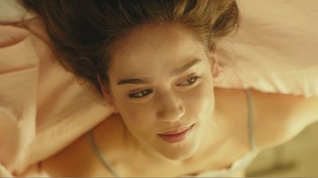 Movie still from “Rings” (2017), directed by F. Javier Gutiérrez – A young woman's face as she lays on a bed; Close Up shot, Overhead angle