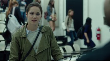Movie still from “Rings” (2017), directed by F. Javier Gutiérrez – A woman in a green jacket standing in front of a group of people; Medium shot, Over the shoulder angle