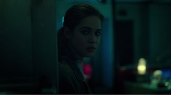 Movie still from “Rings” (2017), directed by F. Javier Gutiérrez – A young woman standing in a dark room; Close Up shot, Over the shoulder angle