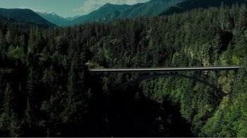 Movie still from “Rings” (2017), directed by F. Javier Gutiérrez – An aerial view of a bridge in the middle of a forest; Extreme Wide shot, High angle