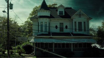 Movie still from “Rings” (2017), directed by F. Javier Gutiérrez – An old house with a large porch in front of a tree; Extreme Wide shot, Low angle