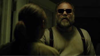 Movie still from “Rings” (2017), directed by F. Javier Gutiérrez – A man with a long beard wearing sunglasses; Close Up shot, Low angle