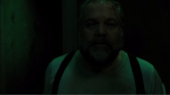 Movie still from “Rings” (2017), directed by F. Javier Gutiérrez – A man with a goatee and a beard is in the dark; Close Up shot, Low angle