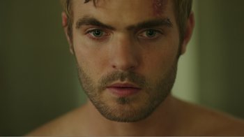 Movie still from “Rings” (2017), directed by F. Javier Gutiérrez – A person with a scar on his face; Close Up shot, Over the shoulder angle