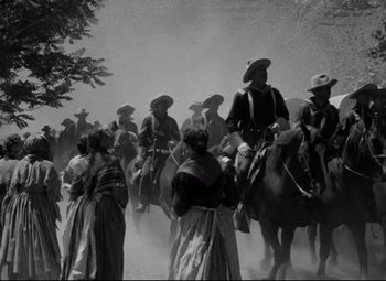 Movie still from “Rio Grande” (1950), directed by John Ford – A black and white photo of people on horses; Wide shot, Low angle