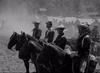 Movie still from “Rio Grande” (1950), directed by John Ford – A black and white photo of men on horses; Wide shot, Low angle
